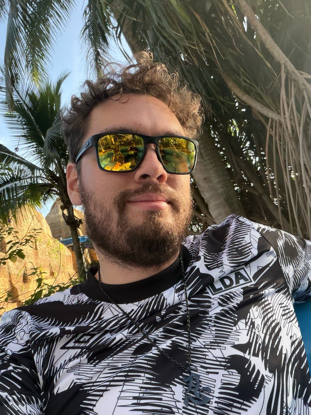 Jose on the beach with palm trees behind him