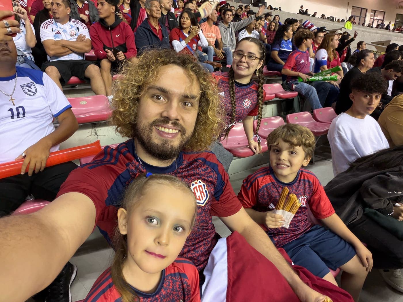 Jose and his children at a Costa Rica national team match, all in red home shirts